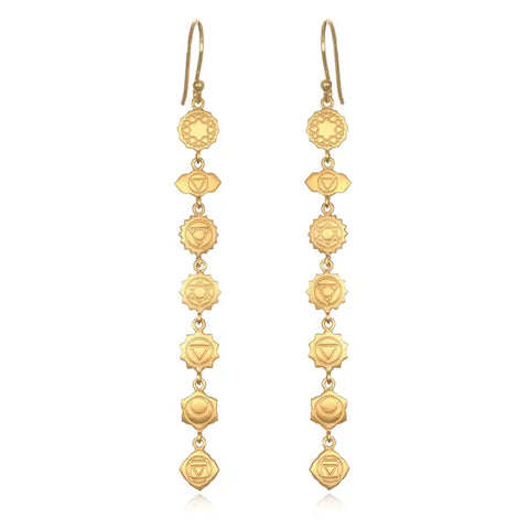 The Aligned in Harmony Earrings are a pair of 18kt gold-plated drop earrings featuring a series of intricately designed round and diamond shapes connected in a linear sequence. Each earring consists of seven connected elements, symbolizing the seven chakras, making fourteen elements in total for the pair. The design is elegantly symmetrical, embodying harmonious balance.