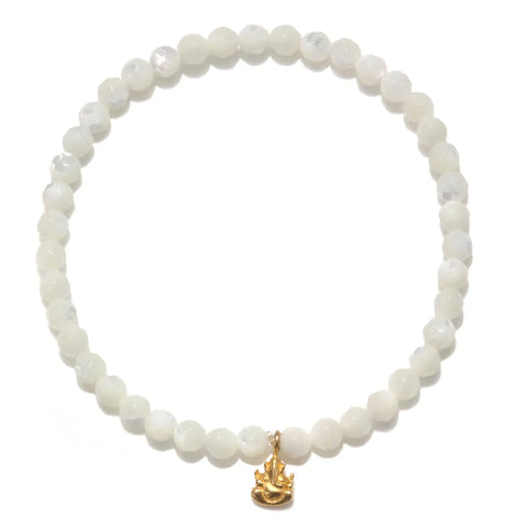 The Mother of Pearl Gold Ganesha Bracelet is crafted with round, white mother-of-pearl beads elegantly arranged in a circle. At its center, it features a small 18kt gold plate charm in the shape of a seated Ganesha, adding to its minimalistic and sophisticated design.