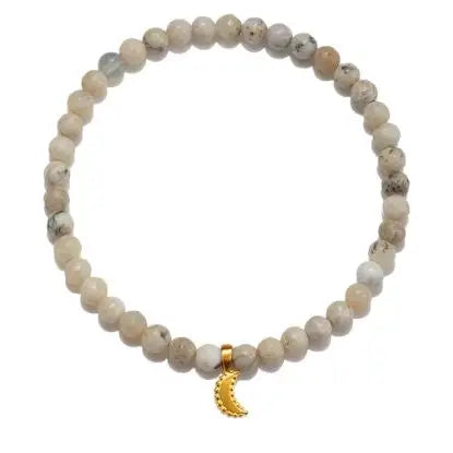 The African Opal Moon Bracelet is composed of uniform, light-colored African Opal beads with subtle marbling. It is accented by a small, 18k gold-toned crescent moon pendant positioned at the center. The plain white background highlights the intricate details of this exquisite bracelet.