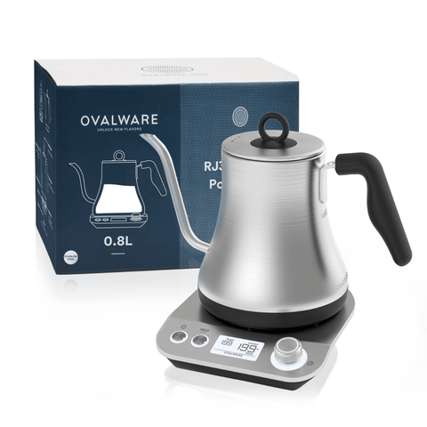 A silver gooseneck electric kettle with a black handle sits on a digital base displaying a temperature of 195°F, perfect for brewing loose leaf tea. The Electric Pour Over Kettle is placed in front of its product box, labeled with "Magic Hour" and "0.8L.