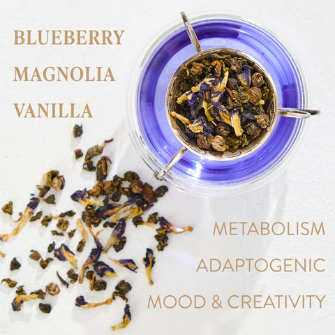 A top-down view of loose leaf tea in a glass teapot reveals a blue brew from the Pisces: Magnolia-Jasmine Blueberries & Cream Tea with Lion's Mane by Magic Hour. Scattered around the teapot are some tea leaves. The image contains text stating "BLUEBERRY MAGNOLIA VANILLA," and "METABOLISM, ADAPTOGENIC, MOOD & CREATIVITY.