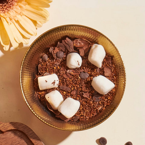 S'mores Loose Leaf Tea with mini marshmallows, carob chips, rooibos, in a gold teacup.