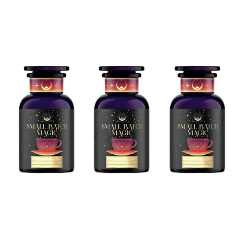 Three dark purple glass bottles of Magic Hour's "Ceremonial Soda Pop Tea Bundle" neatly arranged in a row. Each bottle showcases a label adorned with a golden crescent moon, a starry background, and an illustration of a red teacup on a saucer. These stylish bottles provide guilt-free tea blends that evoke nostalgic flavors like Cherry Cola, Lemon Lime, and Cream Soda.