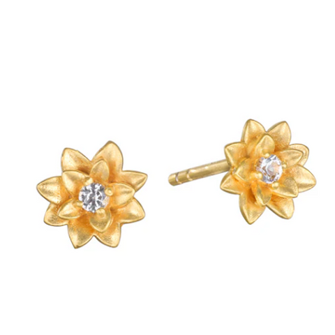 The Soul Renewal Gold Lotus Earrings by Magic Hour are elegantly crafted from gold. Each flower features a sparkling white topaz gemstone at its center. The slightly raised and textured petals create a stunning three-dimensional effect. These earrings symbolize new beginnings and have gold posts for secure fastening.