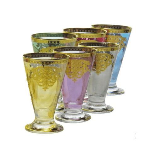 Introducing the Romantic Tea Set - Six Glasses & Pitcher: a set of six tall, footed drinking glasses in a range of colors including yellow, purple, clear, and blue. Each glass is elegantly adorned with ornate gold decorative patterns around the top and intricate designs below, capturing the classic Italian design and timeless elegance of a romantic tea experience.