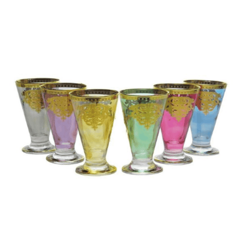 A set of six tall drinking glasses in various colors—clear, pink, blue, green, and yellow—featuring an elegant gold design near the rim inspired by classic Italian aesthetics. These glasses are part of the "Romantic Tea Set" which also includes a matching pitcher; they can be arranged in a semi-circle for an attractive display.