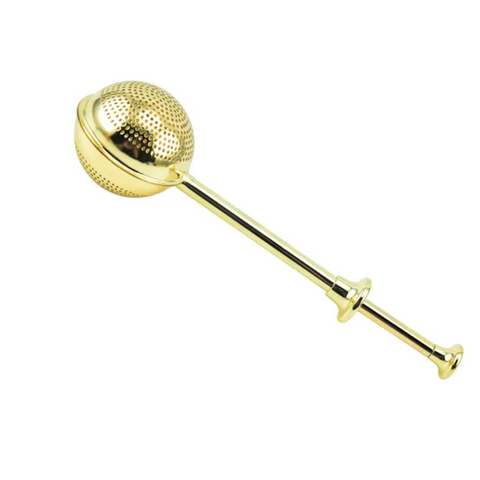 A Golden Wand Tea Strainer from Magic Hour with a perforated spherical compartment and a long handle. The handle, perfect for brewing Magic Hour Tea, ends in a small round knob and has an additional larger round knob at the midpoint for easy gripping. The spherical compartment splits open to hold loose leaf tea.